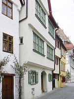 Blick von Osten auf die Straßenfront des Gebäudes mit den großen, die Fassade dominierenden Fensterbändern in den Obergeschossen. Zur Konstruktion und Gliederung der Fenster lagen am Bau keine Befunde mehr vor, doch waren die Fensterbänder bauzeitlich im Fachwerkgefüge des frühen 17. Jahrhunderts angelegt. Die rekonstruierte malachitgrüne Fassung war im Gebäudeinneren umfangreich erhalten geblieben. / Wohnhaus in 89073 Ulm (22.03.2021 - Stefan Uhl)